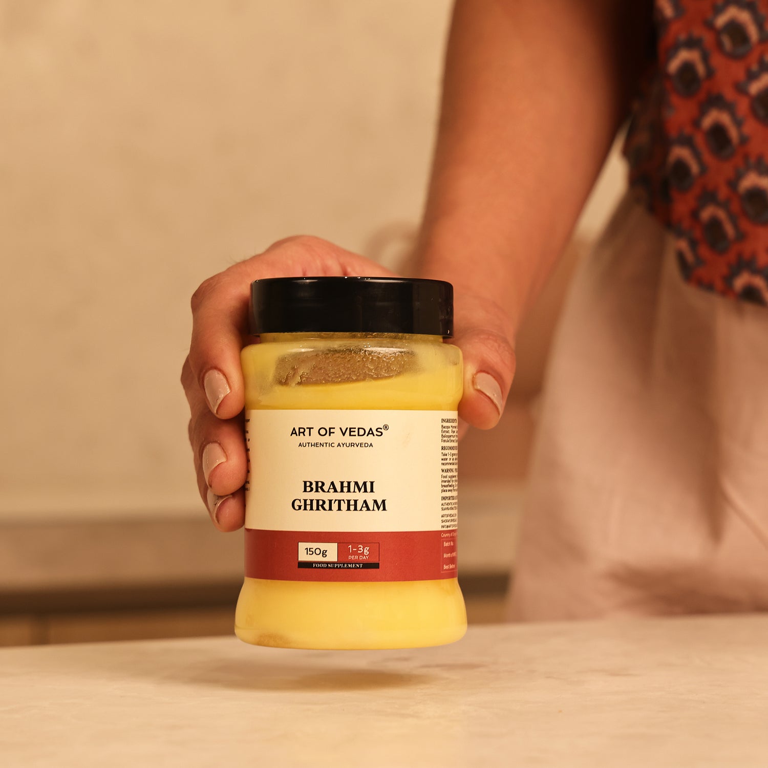 Art of Vedas Ayurvedic Brahmi Ghee - Hand Holding Brahmi Ghritham Jar for Ayurvedic Brain Nourishment and Cognitive Support