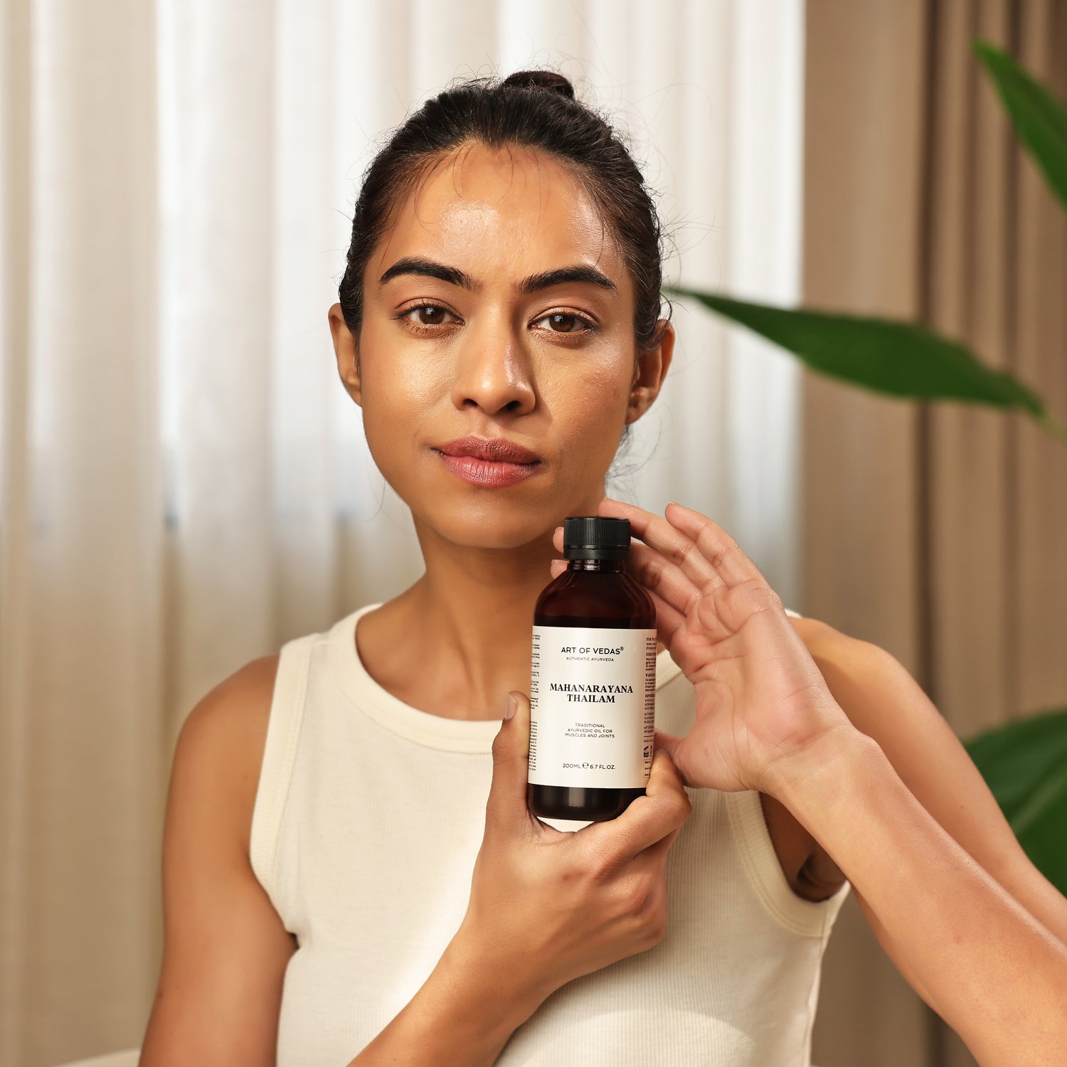 Art of Vedas Mahanarayana Thailam - Woman Holding Authentic Ayurvedic Herbal Oil for Muscle and Joint Relief