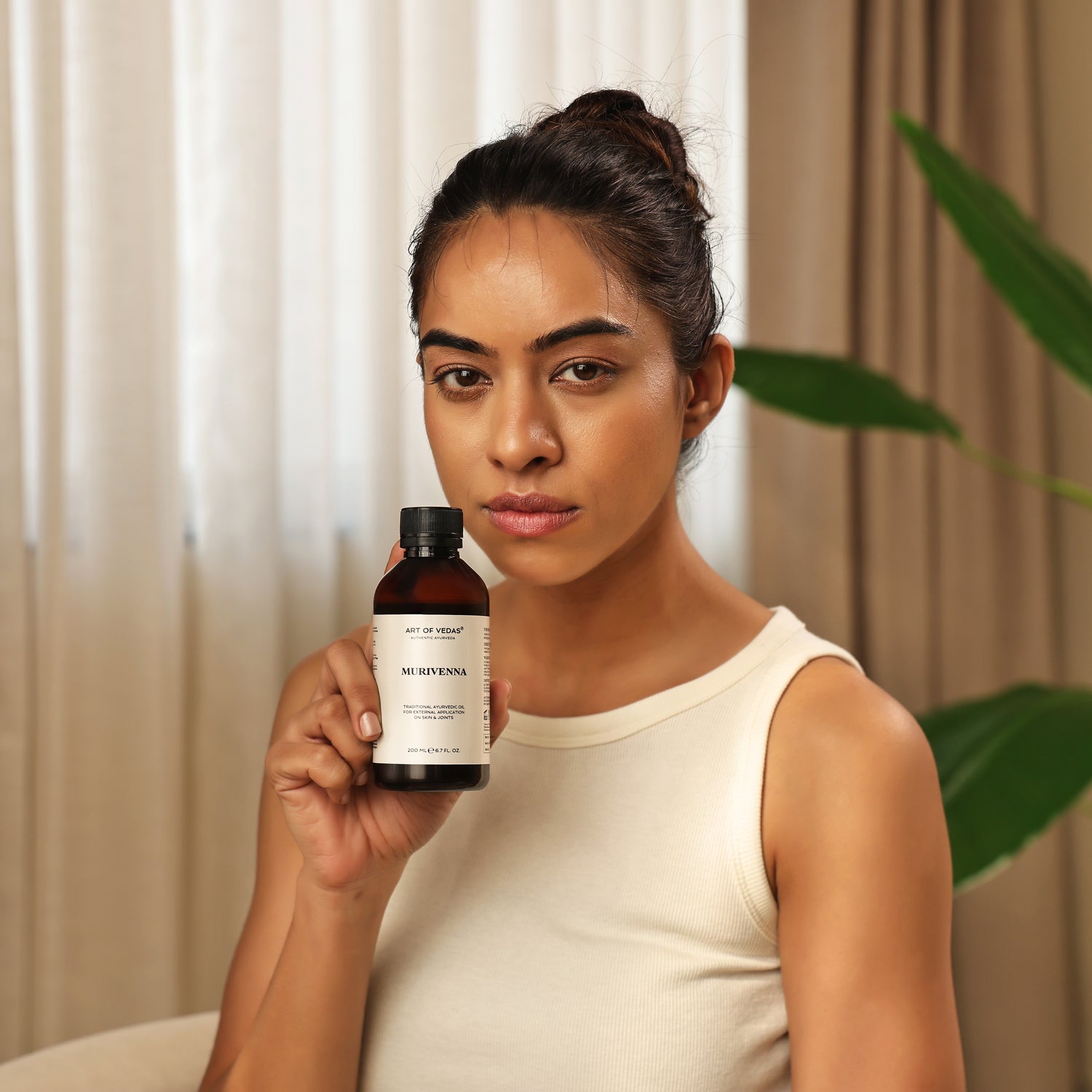 Art of Vedas Murivenna Oil - Woman Holding Authentic Ayurvedic Oil for Wound Healing and Joint Support