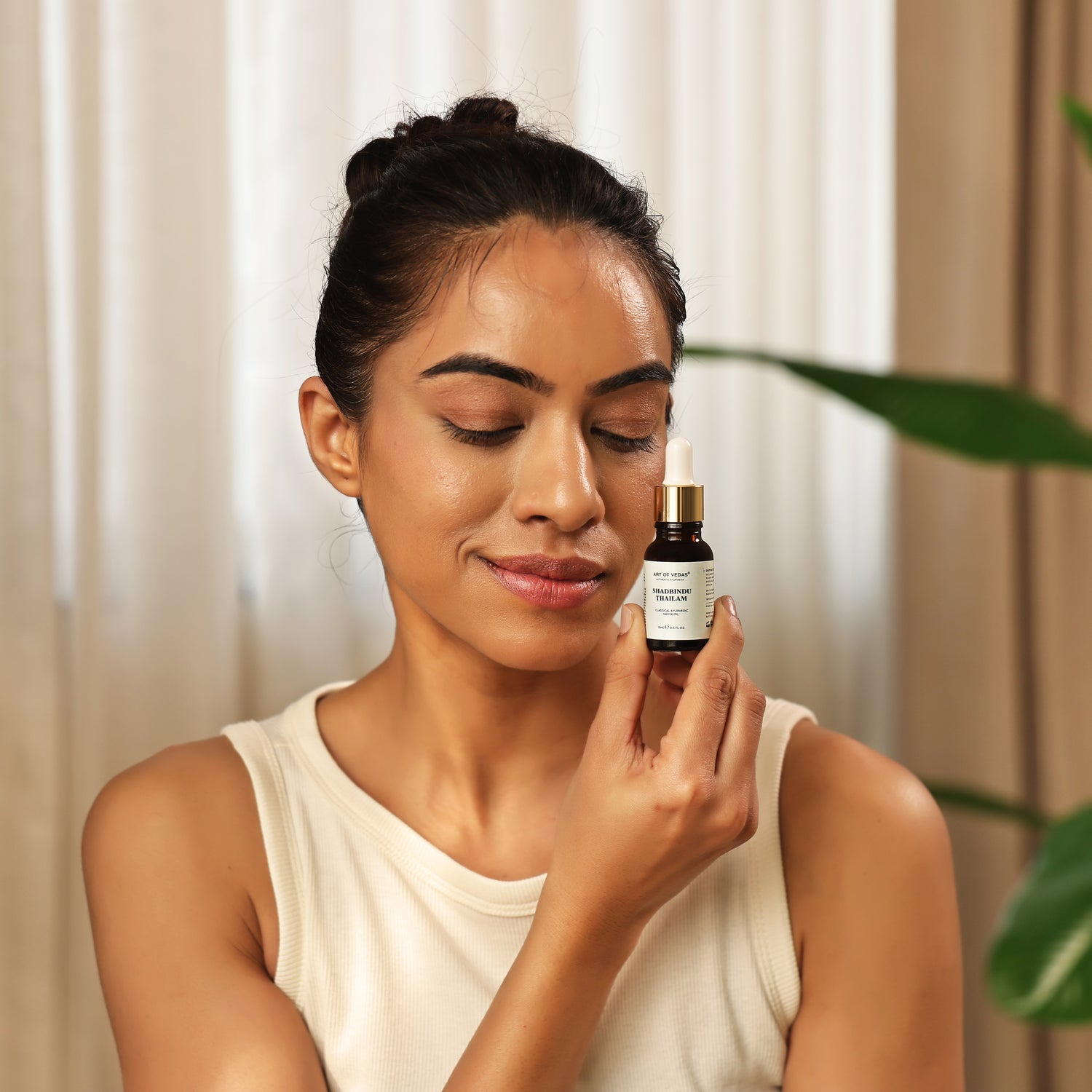 Art of Vedas Shadbindu Thailam - Woman Holding Ayurvedic Nasal Oil Dropper for Sinus Health and Headache Relief